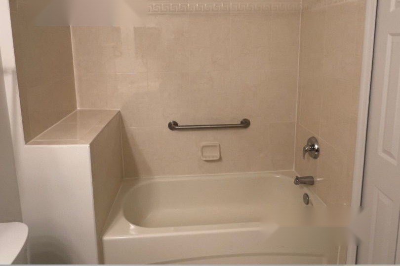 Bathroom tub with beige tile before remodel