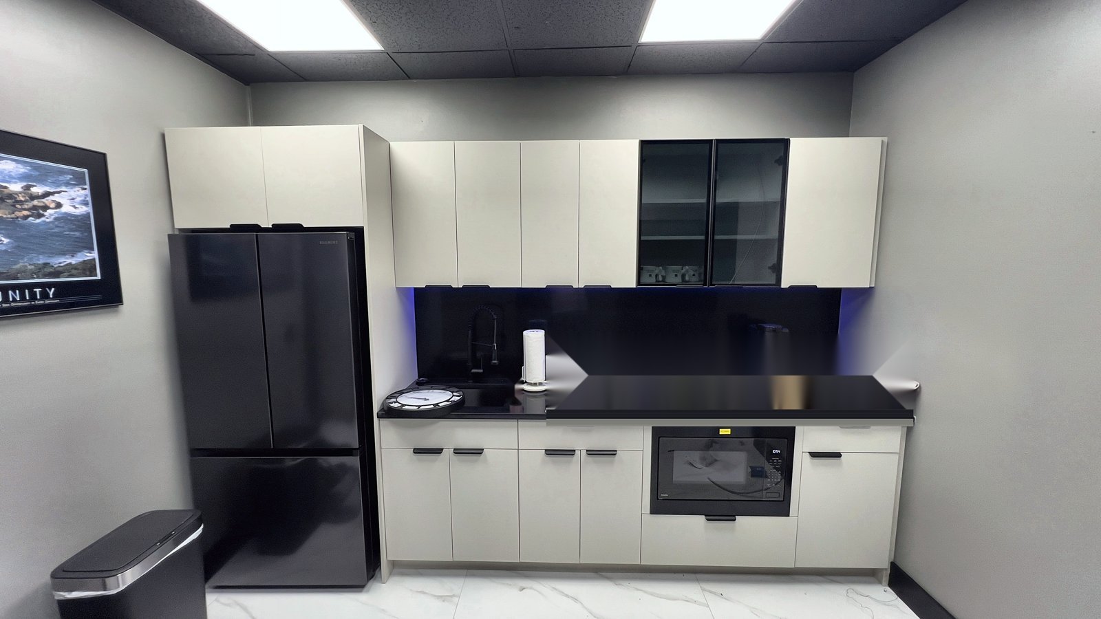 After: new office break room with custom cabinetry, black quartz counters and built-in microwave — commercial remodel in Lake Mary FL
