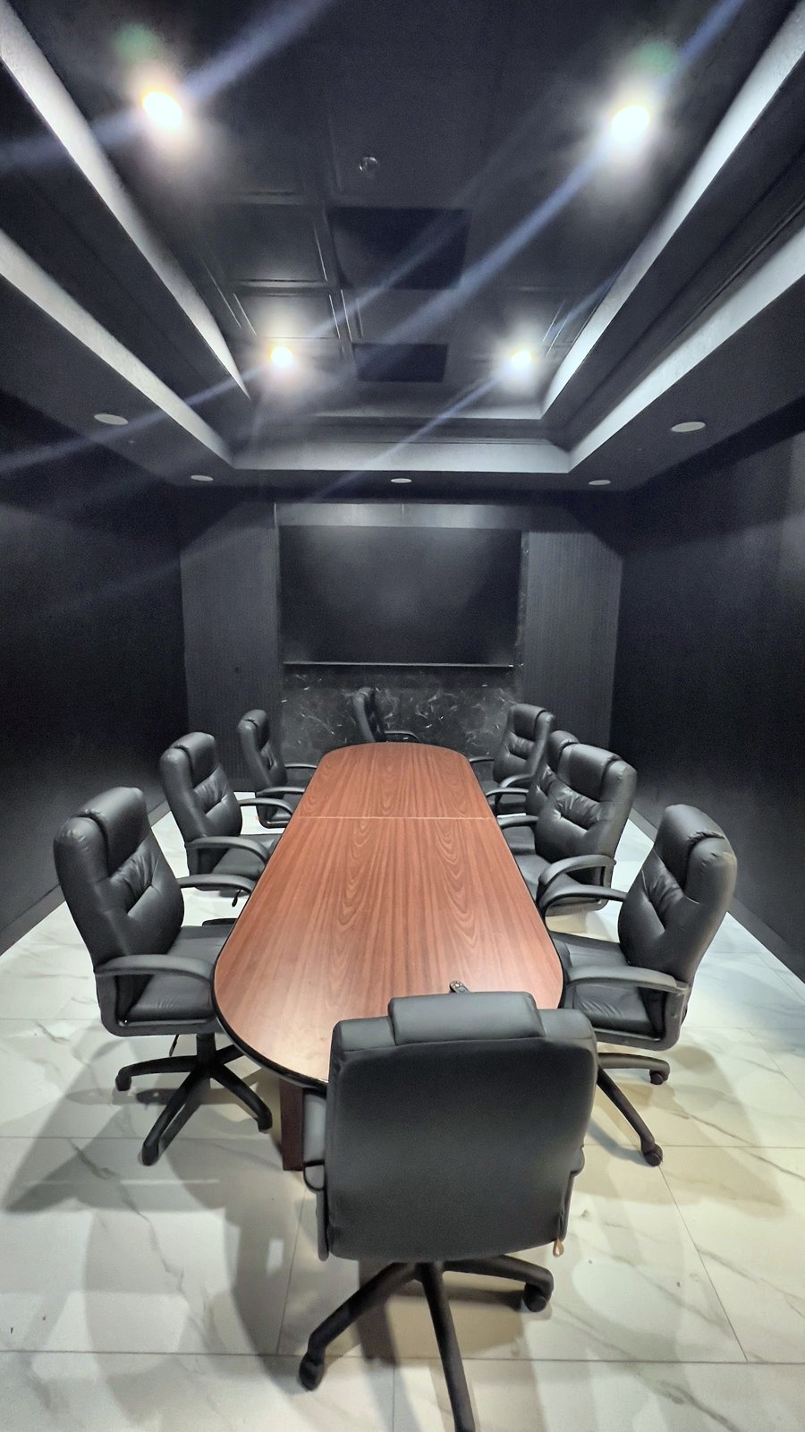 After: conference room with black slat wall, marble accents and LED cove ceiling — commercial office remodel Lake Mary FL