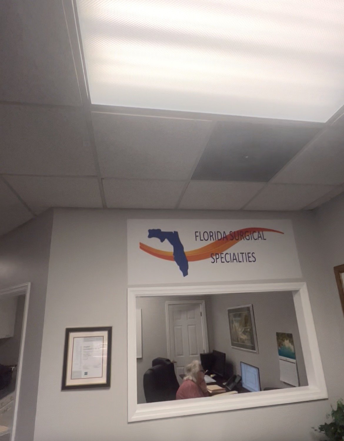 Before: reception area with fluorescent lighting and dated finishes