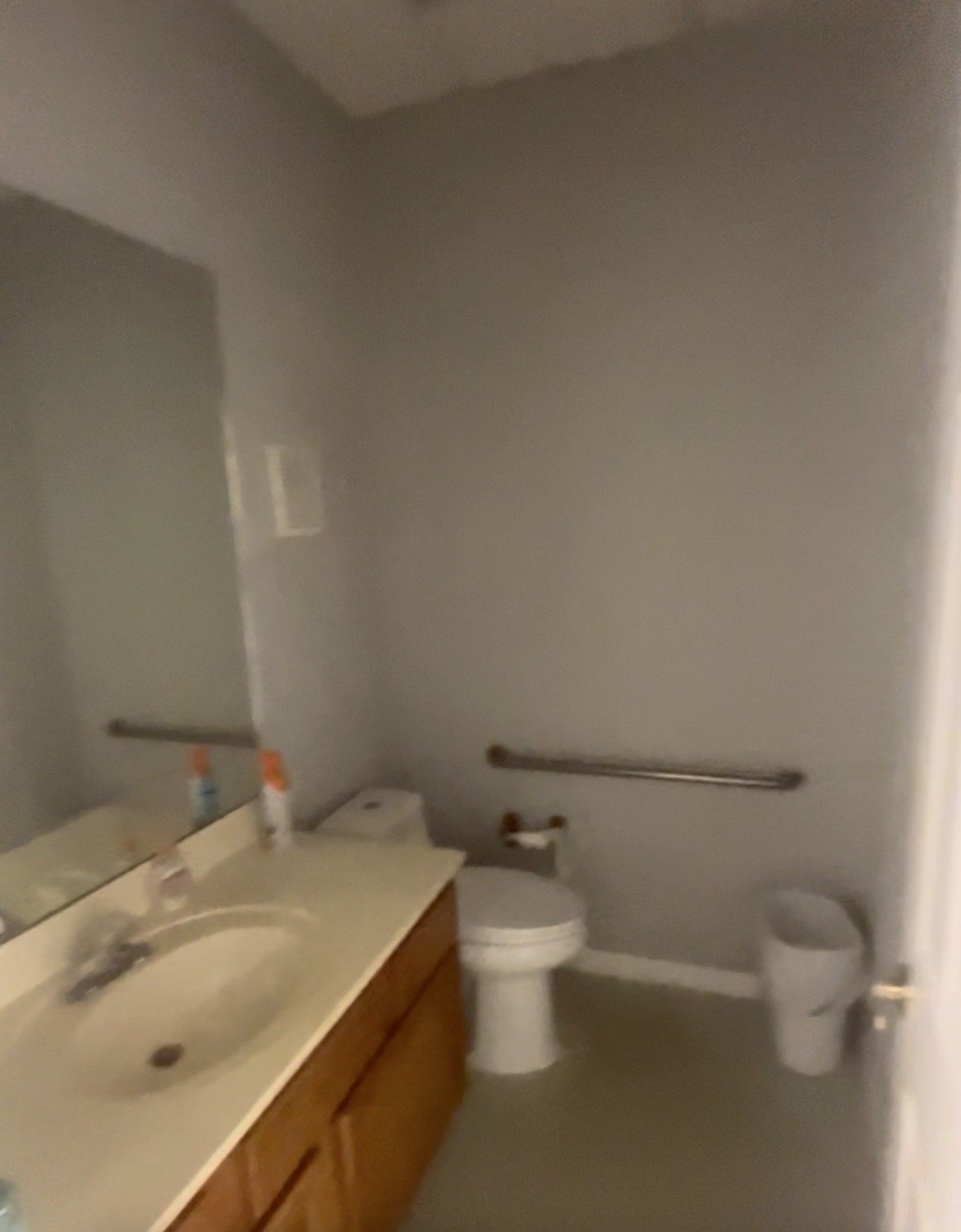 Before: office restroom with oak vanity and beige walls prior to remodel