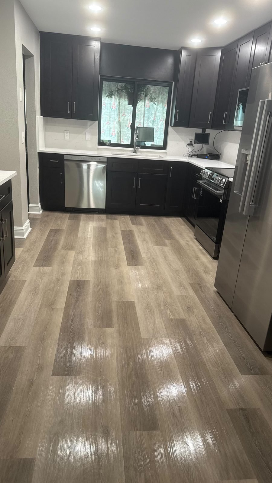 Completed kitchen remodel with dark cabinetry by Kaplan Remodeling & Construction