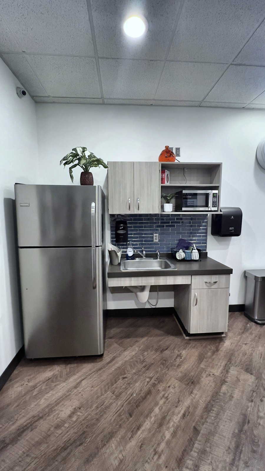 Salon break room with new LVT flooring at 45 degrees and blue subway-tile backsplash — Altamonte Springs FL