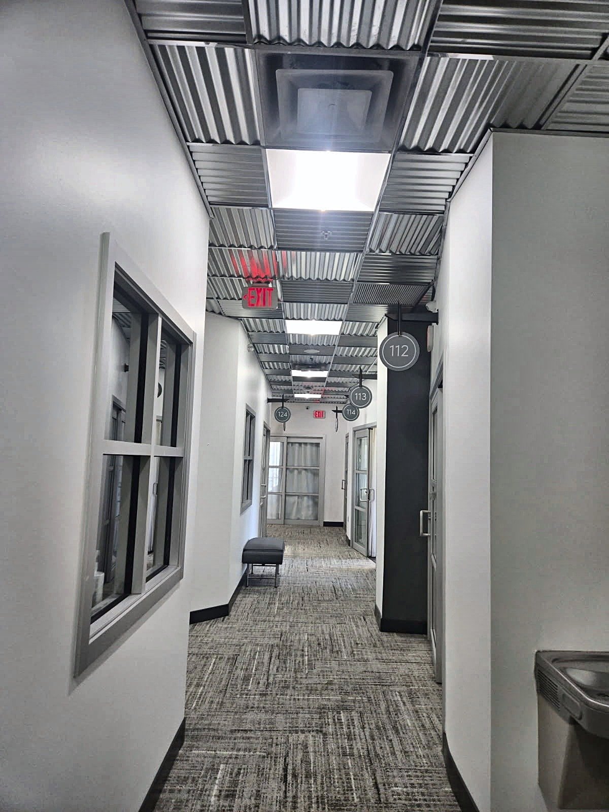 Salon suite hallway with new herringbone carpet tile, fresh paint and corrugated metal ceiling — Altamonte Springs FL